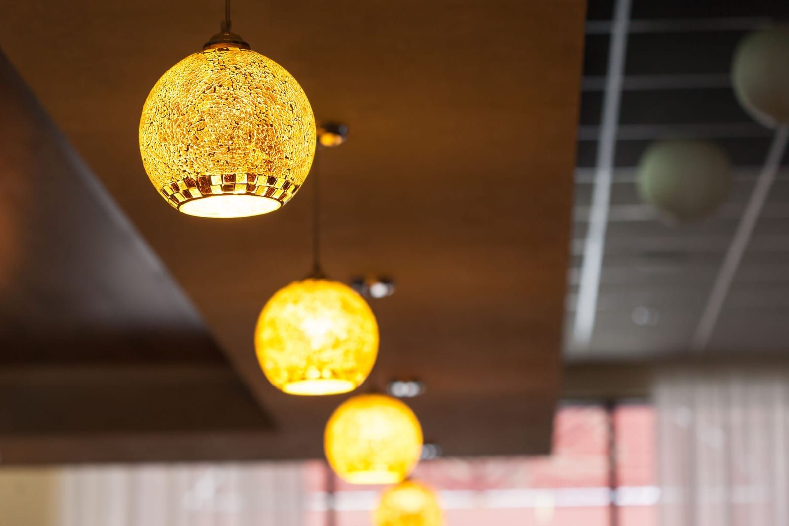 Goldene Pendelleuchten in einem warm beleuchteten Innenraum